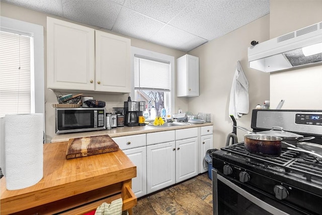 kitchen featuring stainless steel appliances, white cabinets, light countertops, and under cabinet range hood