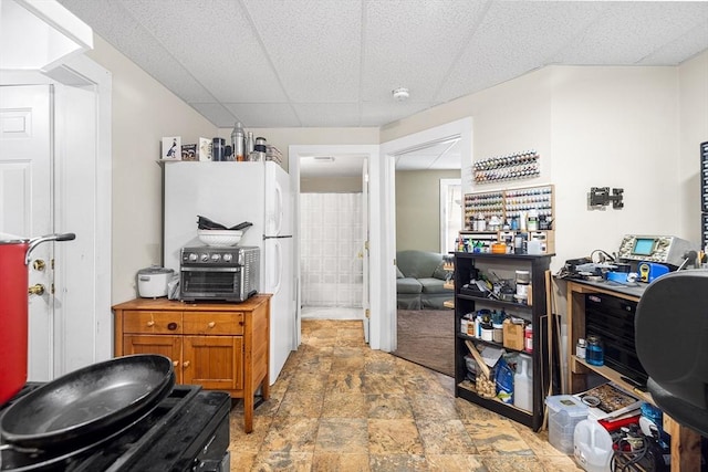 kitchen featuring brown cabinetry and stone finish flooring