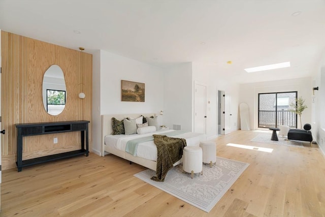 bedroom featuring a skylight, multiple windows, and light wood-type flooring