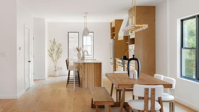 dining area with sink and light wood-type flooring