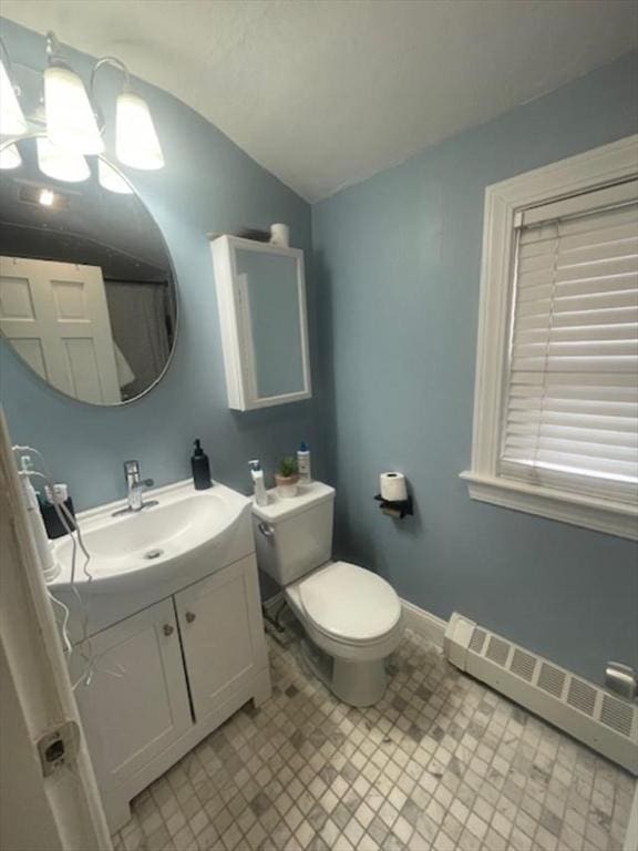 bathroom with a baseboard radiator, baseboards, toilet, vanity, and lofted ceiling