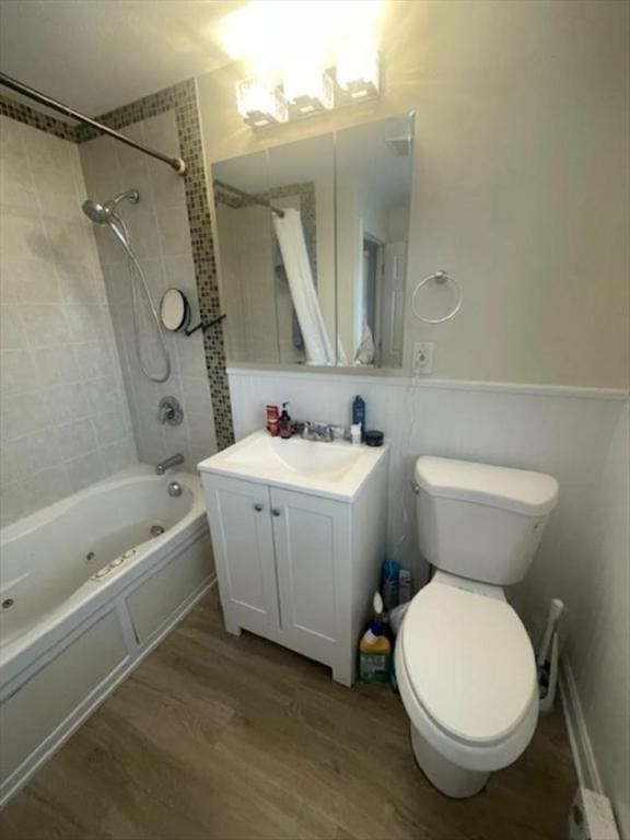 bathroom with toilet, vanity, shower / tub combo with curtain, and wood finished floors