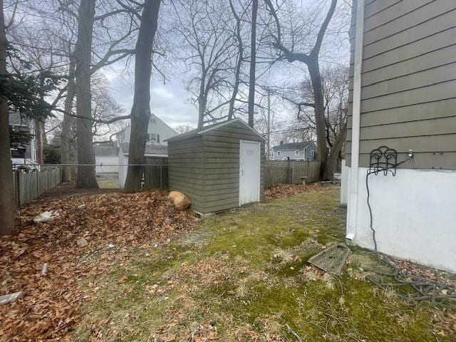 view of yard with a fenced backyard, an outbuilding, and a storage unit