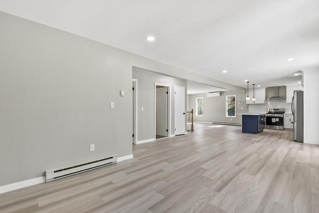 unfurnished living room with baseboards, a baseboard heating unit, recessed lighting, and light wood-style flooring