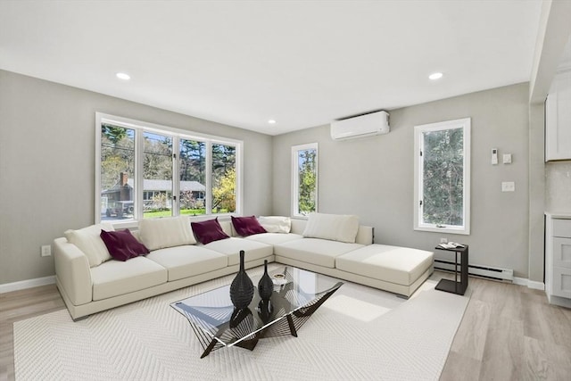 living room with a baseboard heating unit, a wealth of natural light, and light wood finished floors