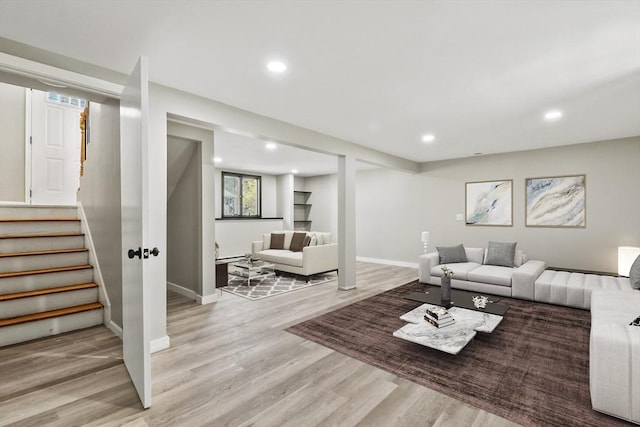living area with stairs, recessed lighting, and light wood-style flooring