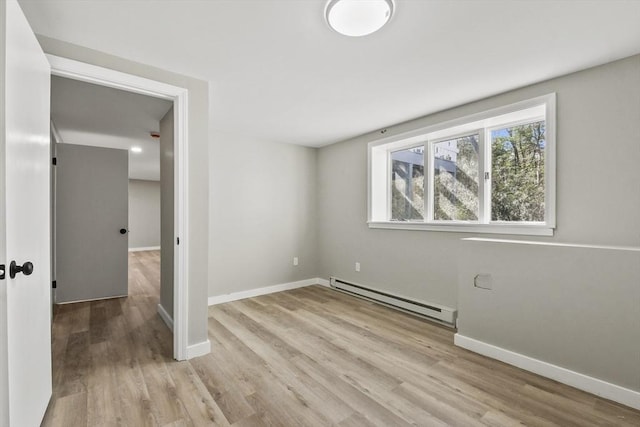 interior space featuring baseboards, a baseboard heating unit, and light wood finished floors