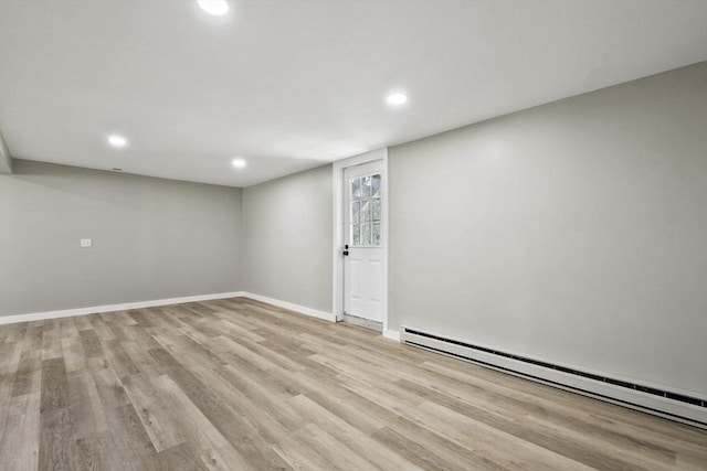 basement featuring baseboards, baseboard heating, recessed lighting, and wood finished floors