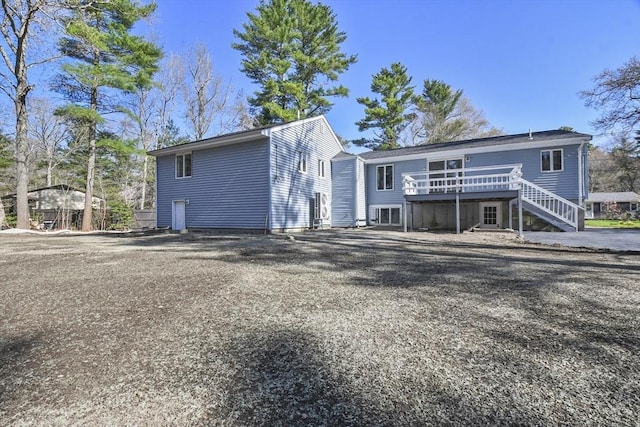 rear view of property with a deck and stairs