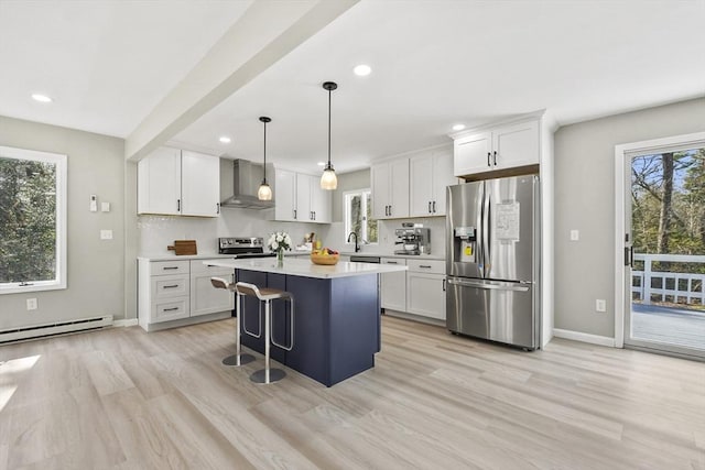 kitchen featuring light countertops, wall chimney exhaust hood, a baseboard radiator, backsplash, and stainless steel appliances