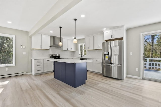 kitchen with wall chimney range hood, a baseboard radiator, white cabinets, stainless steel appliances, and recessed lighting