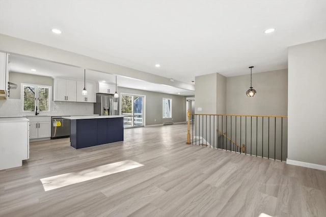 kitchen with stainless steel appliances, open floor plan, a wealth of natural light, and a center island
