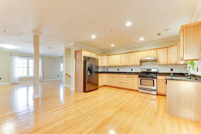 kitchen with appliances with stainless steel finishes, backsplash, light brown cabinetry, and light hardwood / wood-style flooring