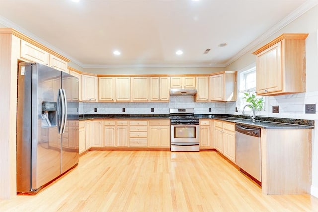 kitchen with appliances with stainless steel finishes, sink, light brown cabinetry, and light hardwood / wood-style flooring