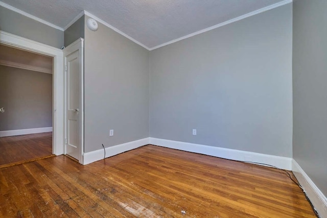 spare room with wood-type flooring, a textured ceiling, and crown molding