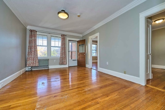 unfurnished bedroom with radiator, light hardwood / wood-style floors, multiple windows, and ornamental molding