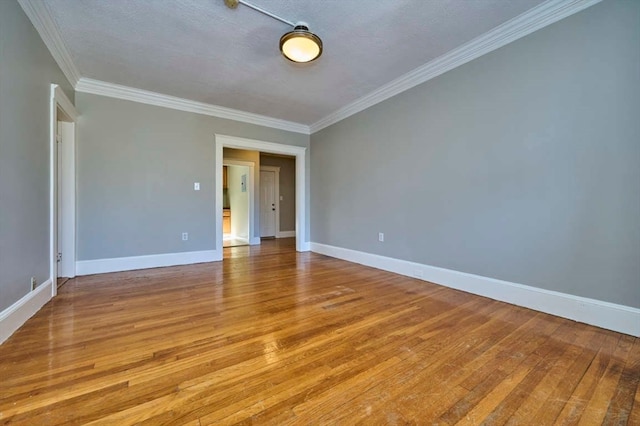 unfurnished room with a textured ceiling, light hardwood / wood-style floors, and crown molding