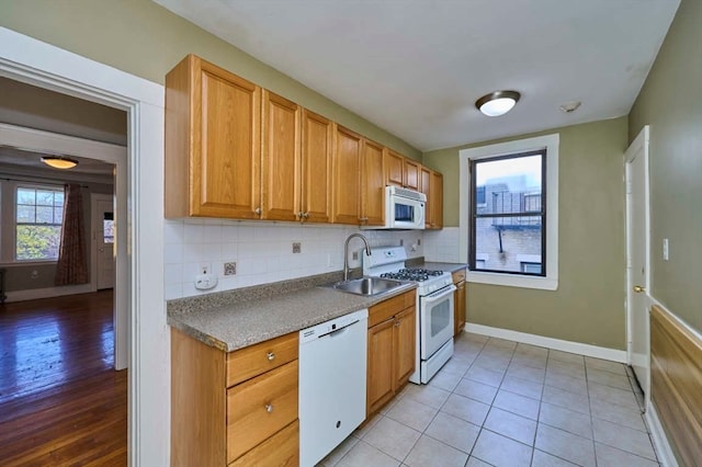 kitchen with light tile patterned flooring, white appliances, backsplash, and sink