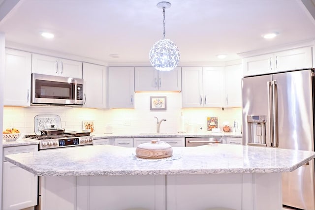 11 Cushing Pl Unit 106, Chelmsford, MA 01824 - kitchen featuring stainless steel appliances, a sink, white cabinetry, backsplash, and decorative light fixtures