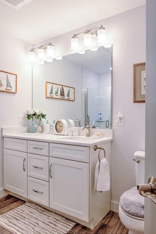 11 Cushing Pl Unit 106, Chelmsford, MA 01824 - full bathroom featuring toilet, a stall shower, wood finished floors, and vanity