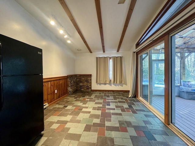 empty room with beamed ceiling and wood walls