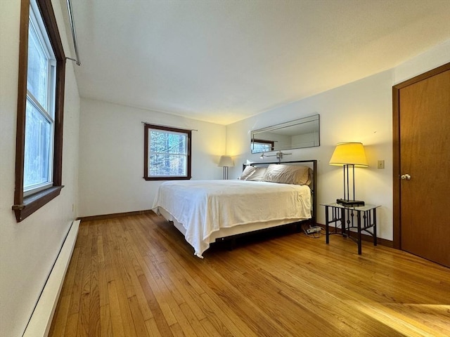 bedroom featuring light wood-type flooring and baseboard heating