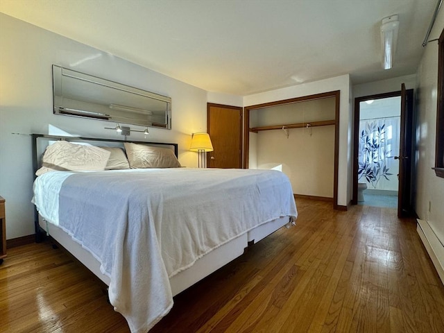 bedroom featuring a closet, dark hardwood / wood-style flooring, and a baseboard radiator