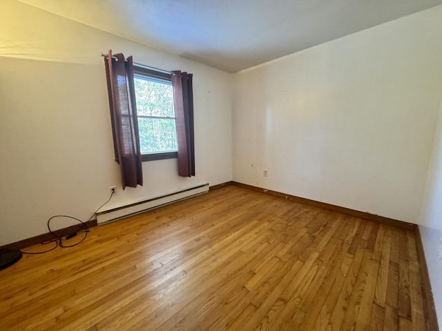 empty room with light hardwood / wood-style flooring and a baseboard radiator