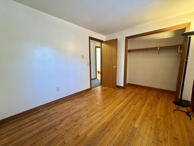 unfurnished bedroom featuring light wood-type flooring and a closet