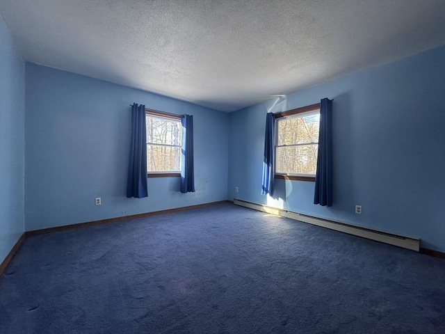 unfurnished room with plenty of natural light, a baseboard radiator, a textured ceiling, and dark carpet