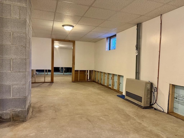 basement with heating unit and a drop ceiling