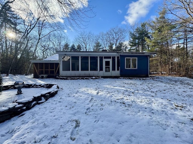 snow covered house with a sunroom