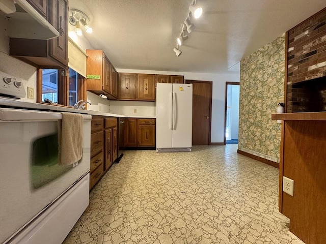 kitchen with a textured ceiling, plenty of natural light, rail lighting, and white appliances