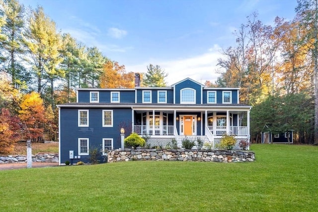 view of front of property with a porch, a chimney, and a front yard