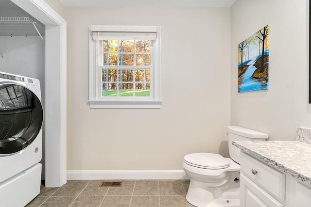 interior space featuring light tile patterned floors, visible vents, washer / dryer, laundry area, and baseboards