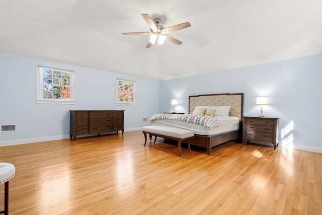 bedroom with lofted ceiling, light wood finished floors, visible vents, and baseboards