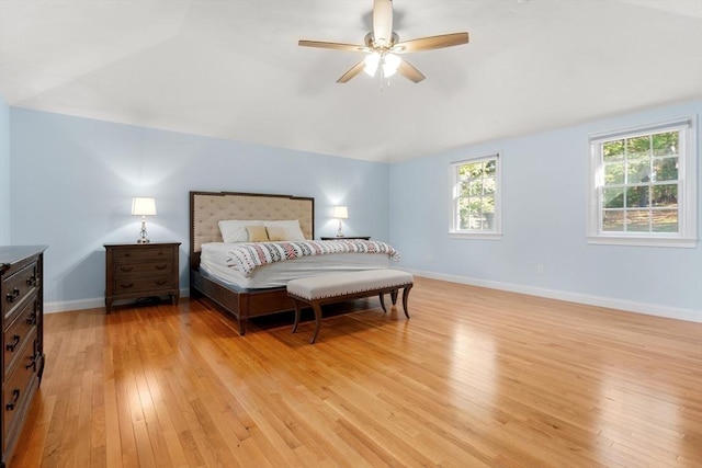 bedroom featuring lofted ceiling, light wood finished floors, ceiling fan, and baseboards