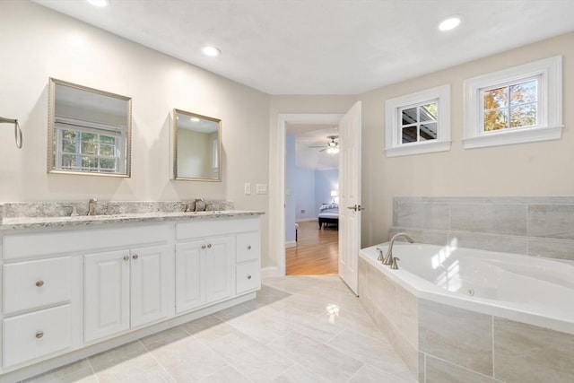 ensuite bathroom featuring a whirlpool tub, connected bathroom, a sink, and double vanity