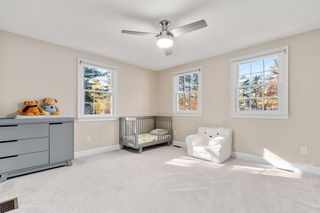 sitting room with a ceiling fan, light carpet, visible vents, and baseboards