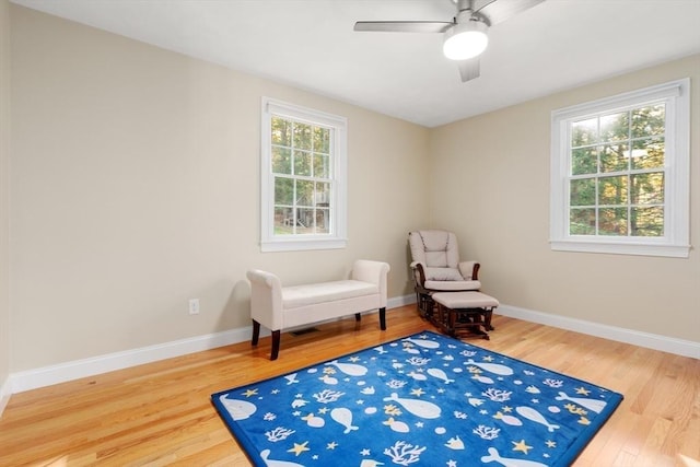 living area featuring a wealth of natural light, baseboards, and wood finished floors