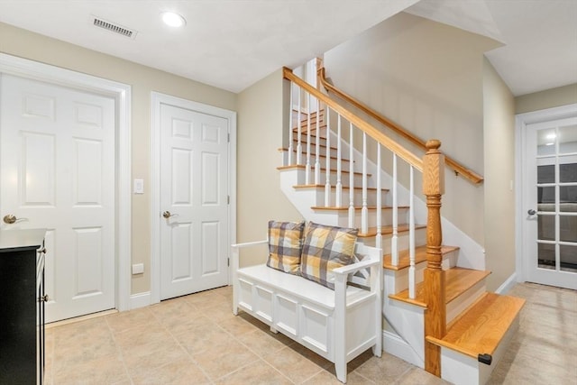 stairway featuring visible vents, baseboards, and tile patterned floors