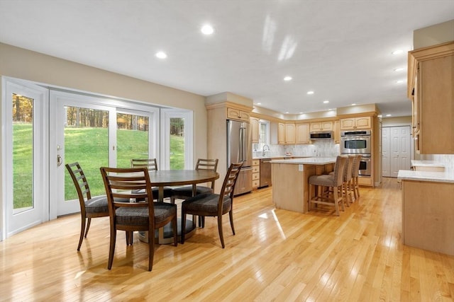 dining space with light wood finished floors and recessed lighting