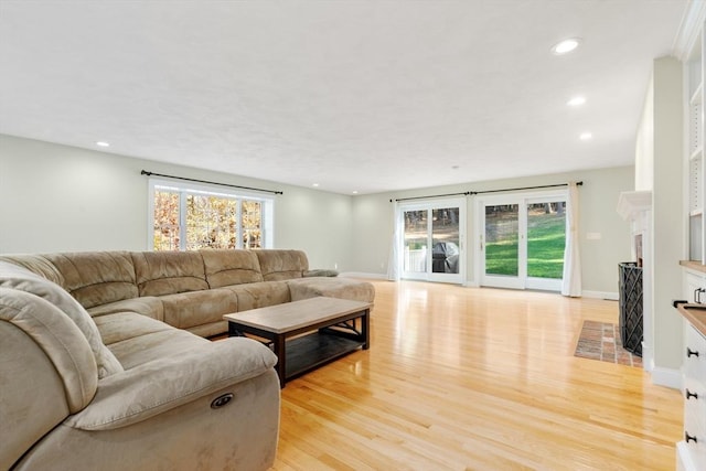 living room featuring recessed lighting, plenty of natural light, and light wood-style floors