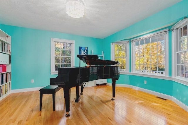 sitting room featuring a notable chandelier, wood finished floors, visible vents, and baseboards