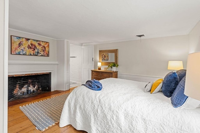 218 Washington St Unit 5, Marblehead, MA 01945 - bedroom with wood finished floors, crown molding, and a fireplace with flush hearth