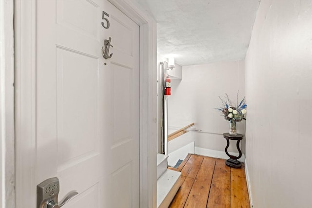 218 Washington St Unit 5, Marblehead, MA 01945 - corridor featuring baseboards, light wood finished floors, an upstairs landing, and a textured ceiling