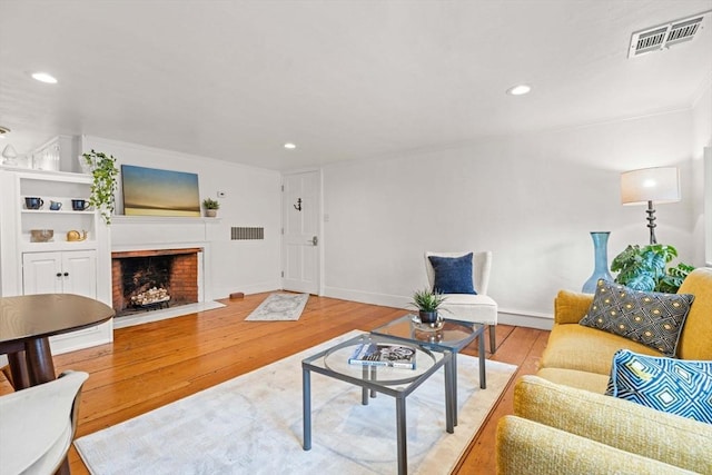 218 Washington St Unit 5, Marblehead, MA 01945 - living area with wood finished floors, a brick fireplace, ornamental molding, recessed lighting, and baseboards