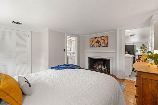 218 Washington St Unit 5, Marblehead, MA 01945 - bedroom with light wood-style floors, a fireplace, a closet, and ensuite bathroom