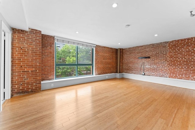 42 8th St Unit 1301, Boston, MA 02129 - unfurnished living room featuring wood finished floors, brick wall, and recessed lighting