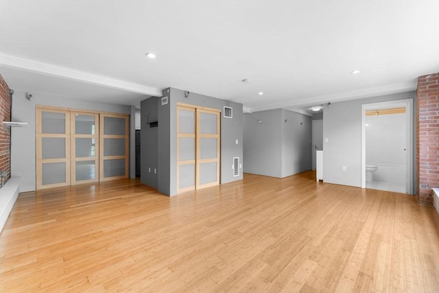 42 8th St Unit 1301, Boston, MA 02129 - unfurnished living room featuring a fireplace, light wood finished floors, recessed lighting, and brick wall